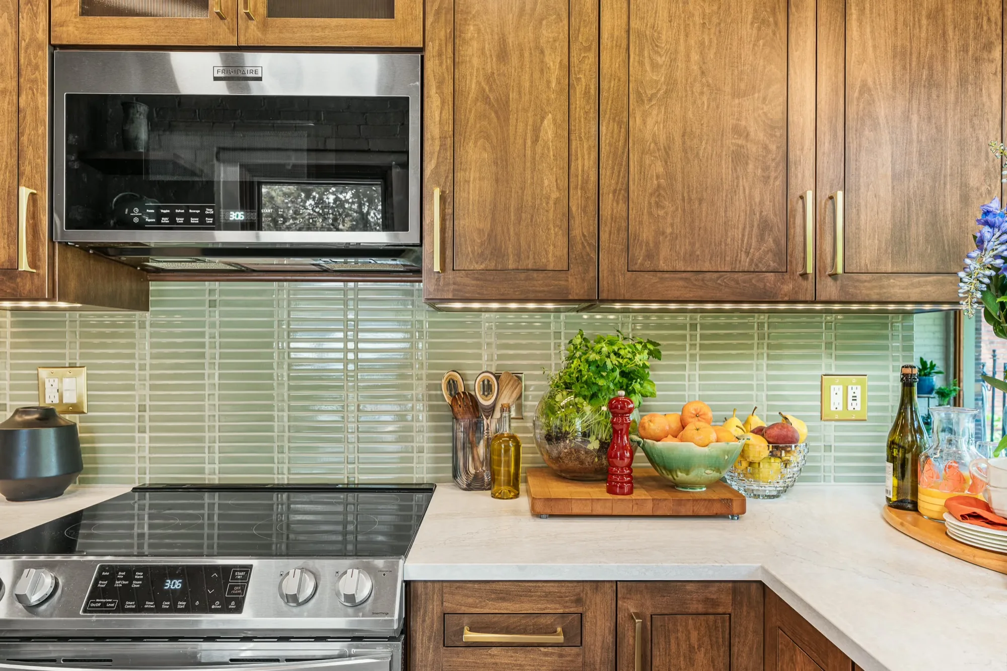 Kitchen with custom Amish cabinetry in natural wood and a handcrafted glass tile backsplash