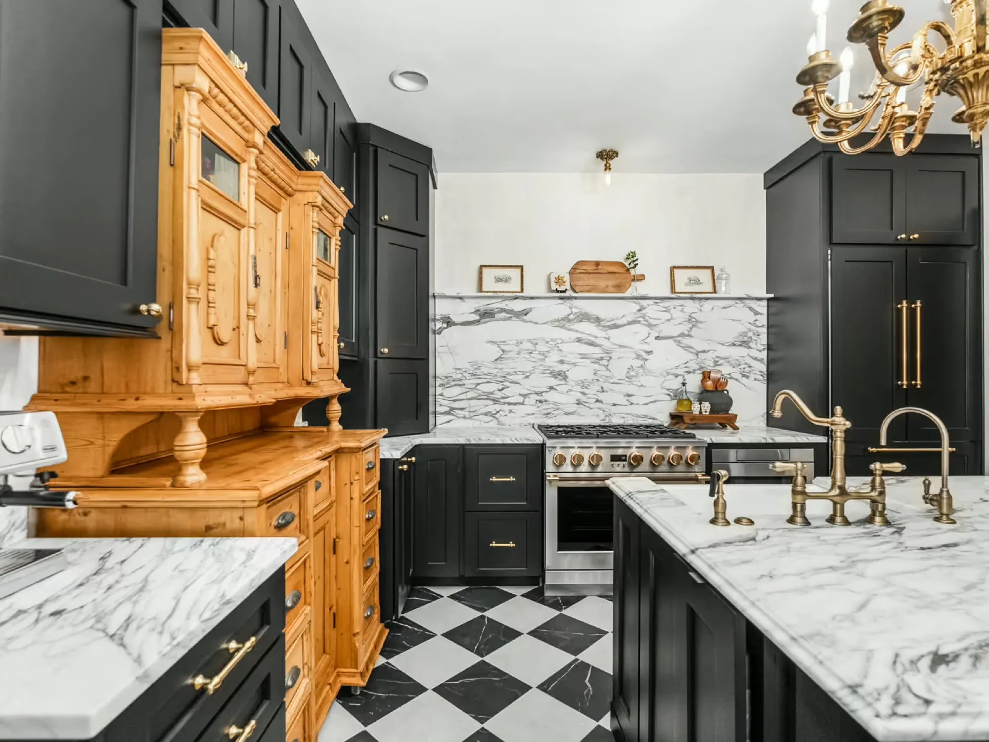 Kitchen with dark green cabinetry, marble counters, brass fixtures and a black and white checkerboard floor