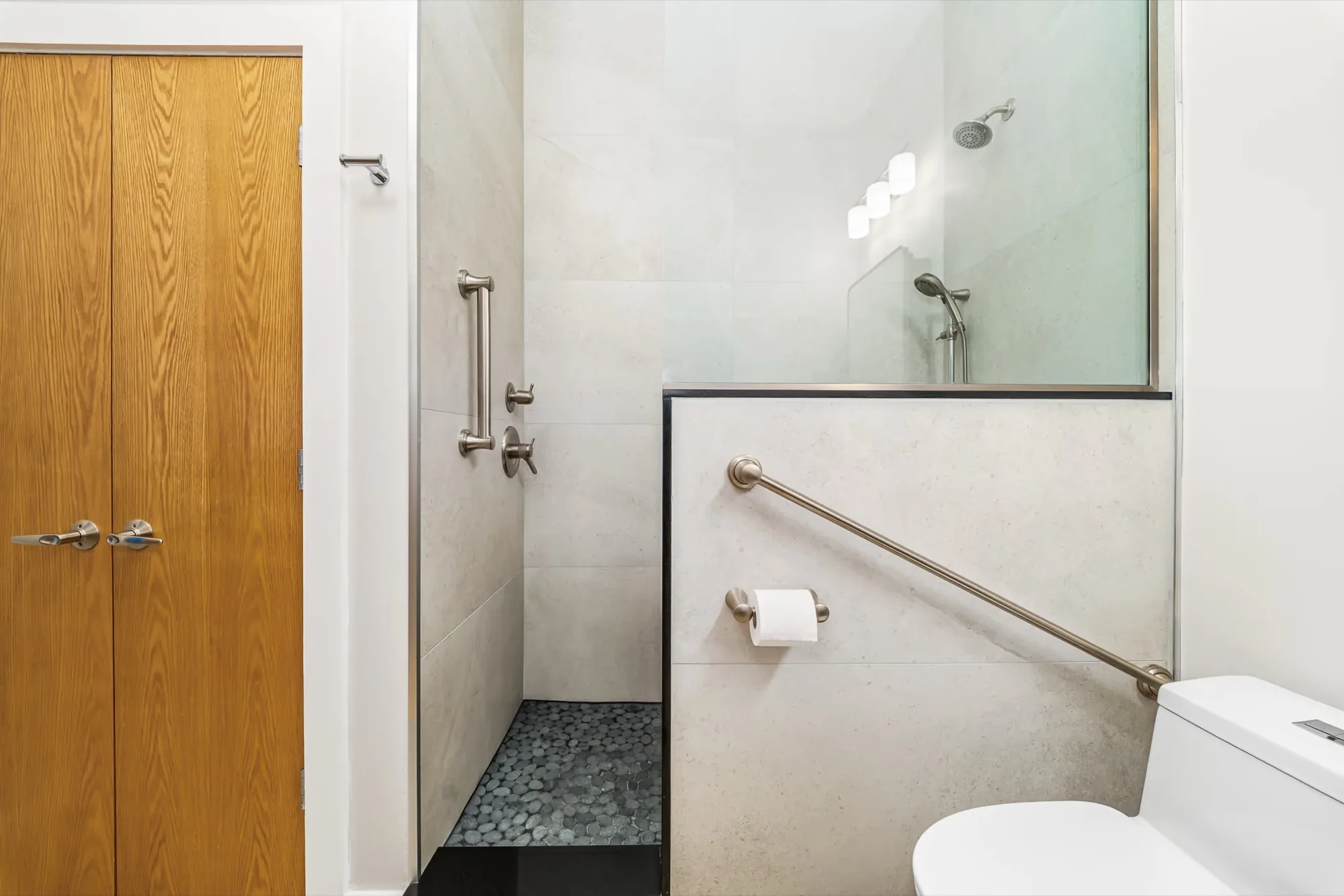 Accessible bathroom with a curbless shower, grab bars and a folding seat
