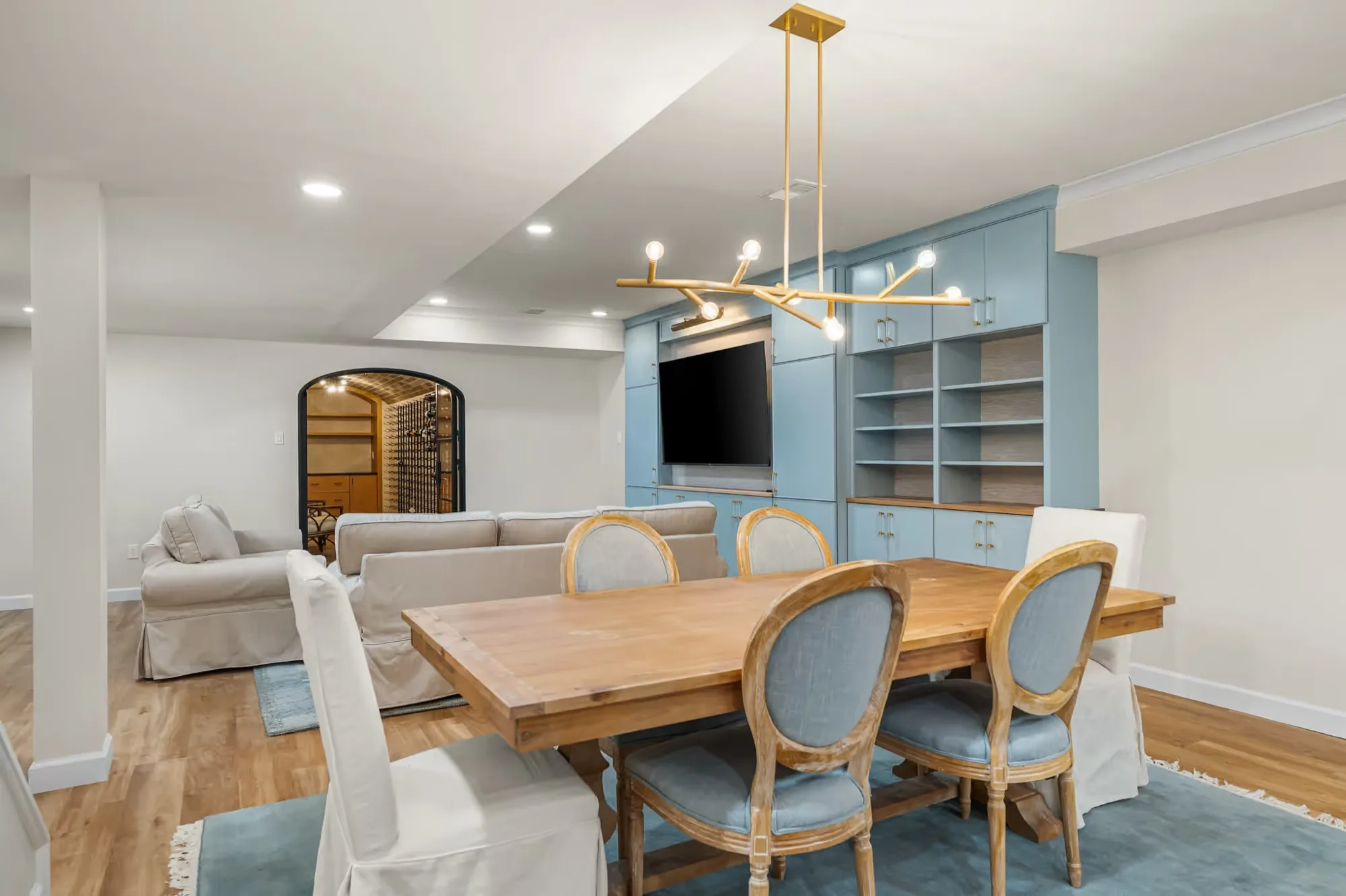Finished lower level with a dining table, built-in shelving and a wall-mounted television